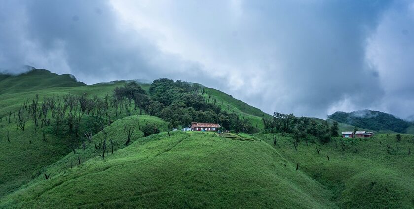 A picture with lush greenery and clouds surrounding it, making it a scenic view to witness.