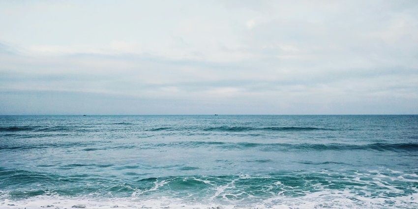 A mesmerising view of a turquoise body of water with low soft tides during the daytime.