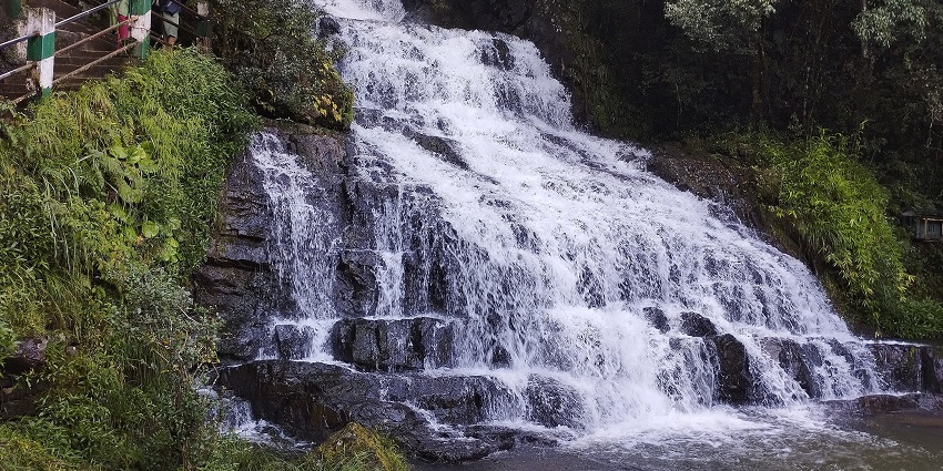 Elephant waterfall cascading thrift rocks surrounded by lush greenery - camping in Shillong.