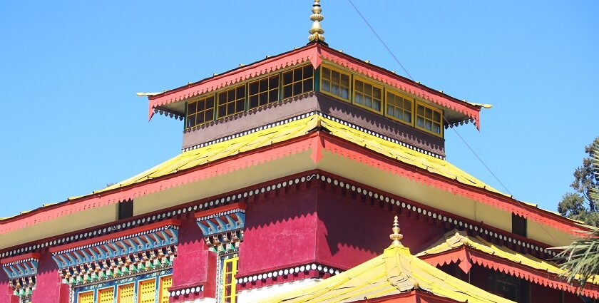 A stunning view of a monastery in Sikkim with red and yellow architecture during the day.