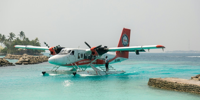 A glimpse of a seaplane standing amid the crystal-clear waters that landed on a reef.