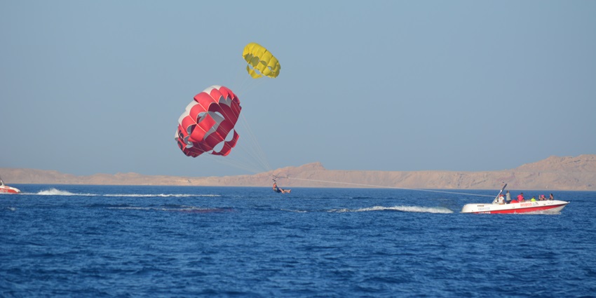 A pristine beach with golden sands and turquoise waters, offering thrilling water sports like jet skiing and parasailing.