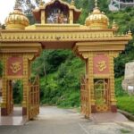 Entry gate of Jatoli Mandir with traditional design, ornate carvings, and a welcoming atmosphere.