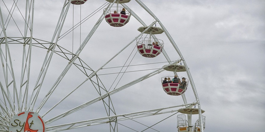 A picture of a Ferris wheel at an amusement park in Delhi, under a cloudy sky