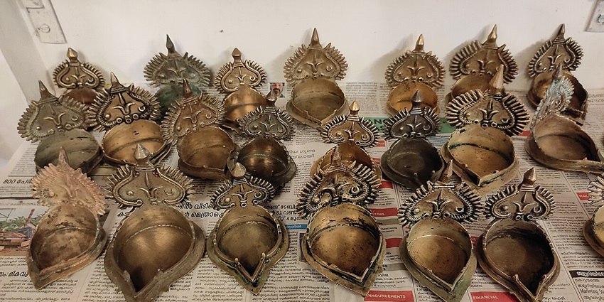 A picture of handmade metal diyas placed on display at Kerala Art and Craft Village