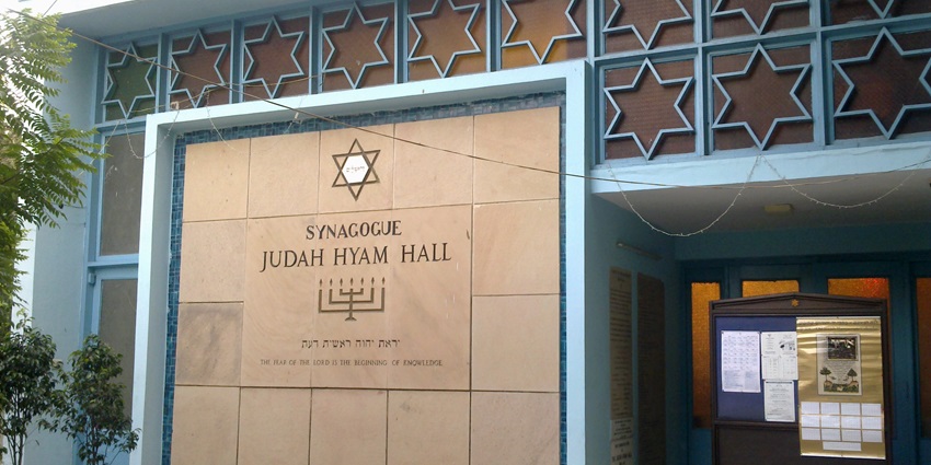 A picture of the exterior of a Jewish synagogue in Delhi, with flower pots placed in front