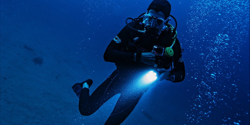 A man exploring the depths of water while diving in deep places