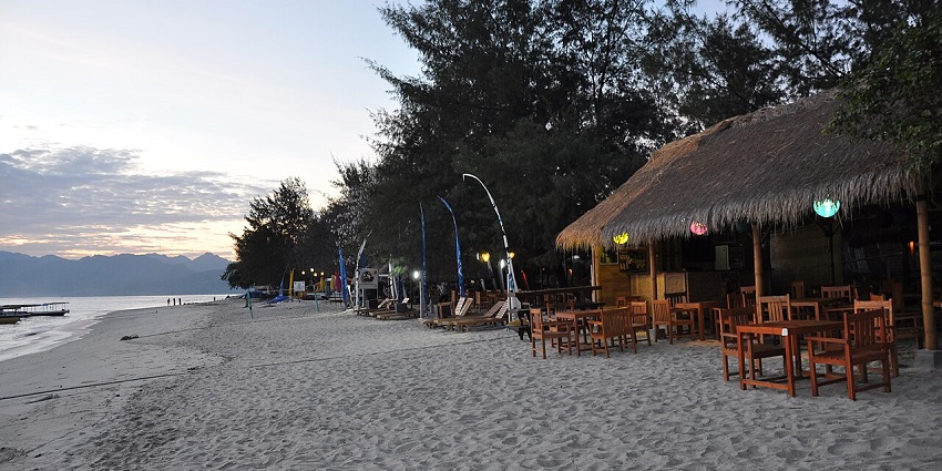 A picture of a beach at Gili island with eateries and restaurants on the right side