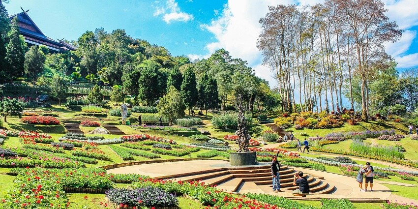 Beautiful park with lush green grass, colourful flowers, and well-maintained paths.