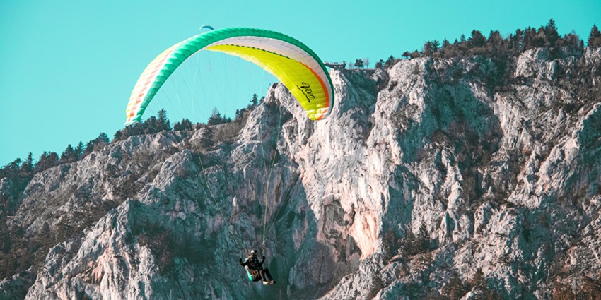 Paraglider Flying in the Air Near a Cliff - one of the paragliding in Kashmir, Astanmarg