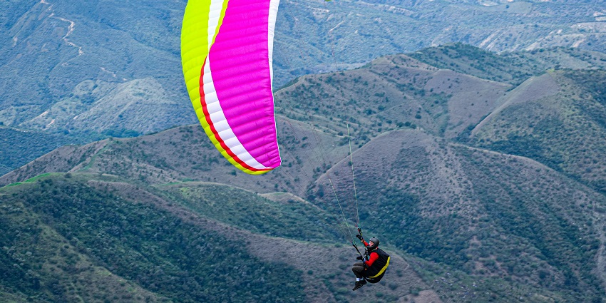 View of a Paraglider Flying over Hills - Dhanua is one of the best spots for paragliding in Jammu