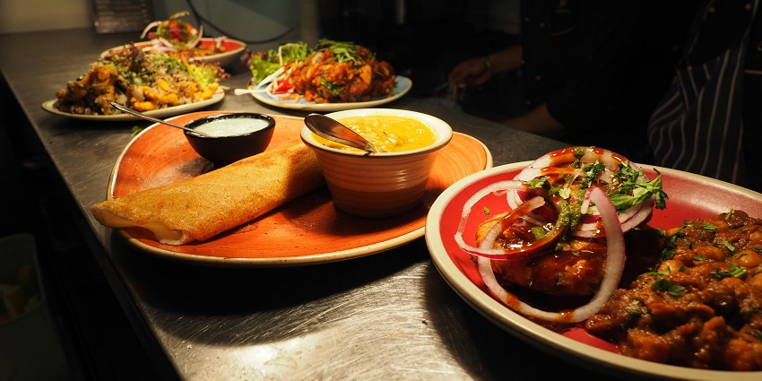 a colourful platter filled with various delicious foods, including fruits, cheeses, and meats.