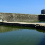 A quaint view of serene waters and majestic buildings, a famous tourist spot in Sri Lanka.