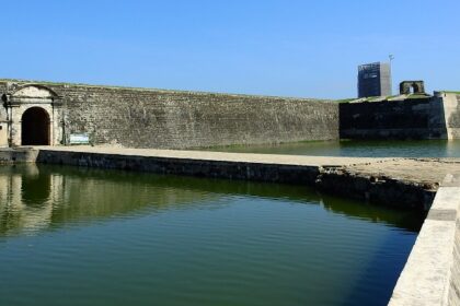 A quaint view of serene waters and majestic buildings, a famous tourist spot in Sri Lanka.