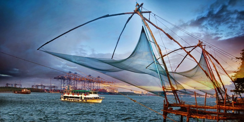 A picture of a historical fort with a cruise ship sailing in the background in the Arabian Sea
