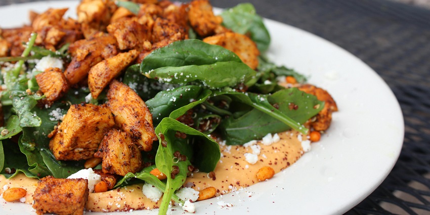 A plate of golden fries garnished with fresh green leaves, ready to be enjoyed.