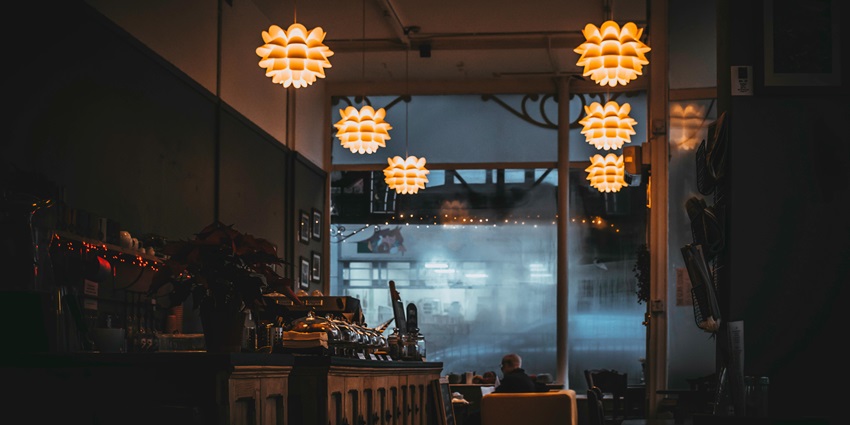 A picture showcasing the cosy ambience of a restaurant with yellow lamps
