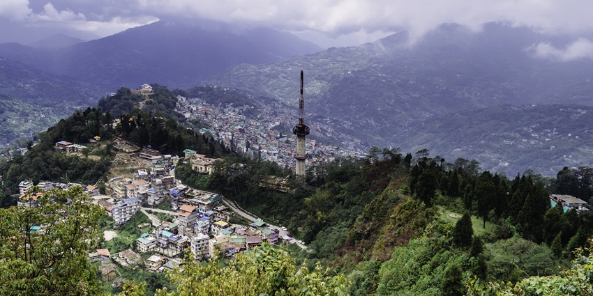 A majestic bird-eye view of Gangtok City with lush greenery and mountains in the background