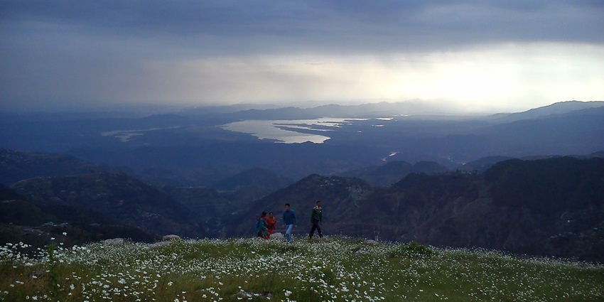 A picture of a mountain peak with a lake behind it