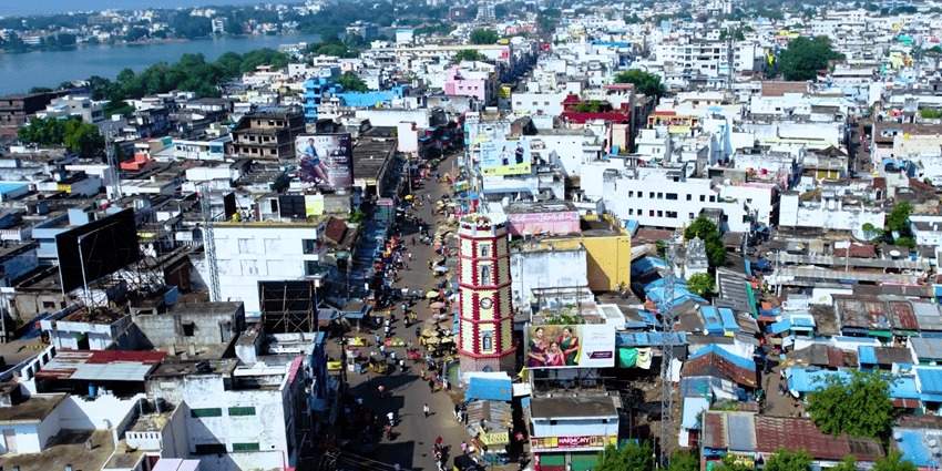 An aerial view of a clock tower in Andhra Pradesh with the local settlement in background