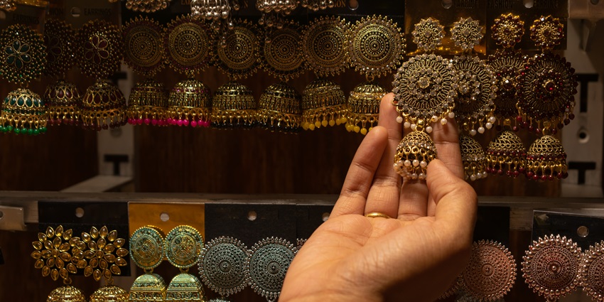 A picture of a woman selecting earrings from a vast collection of pieces while wedding shopping in Kolkata
