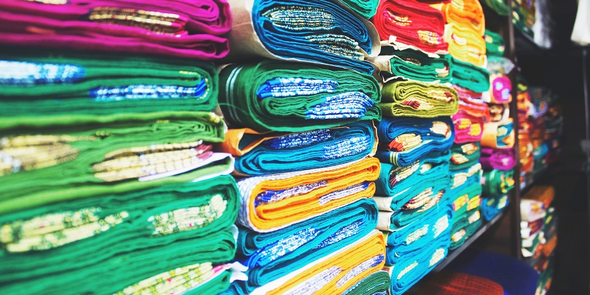 A beautiful view of colourful sarees kept on a shelf in a shop for shopping lovers.