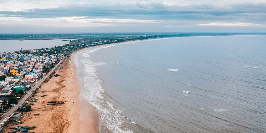 A mesmerising aerial view of the Ghoghla Beach with waves touching the seashore.