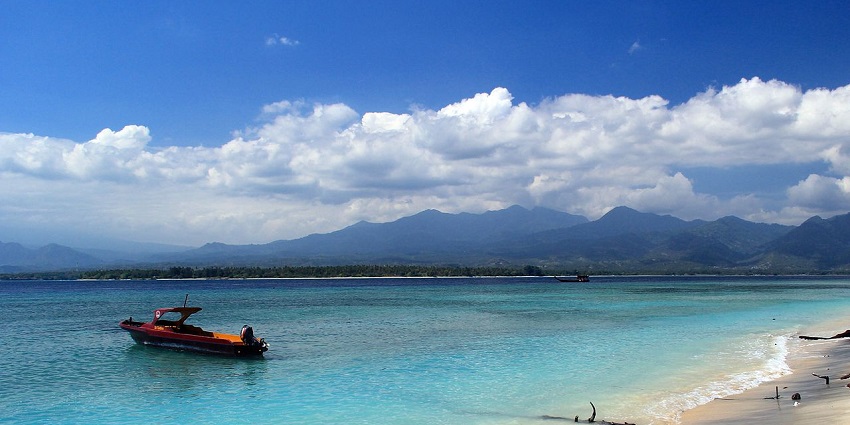 A popular destination for scuba diving in Gili Islands with a boat sailing away from the shore