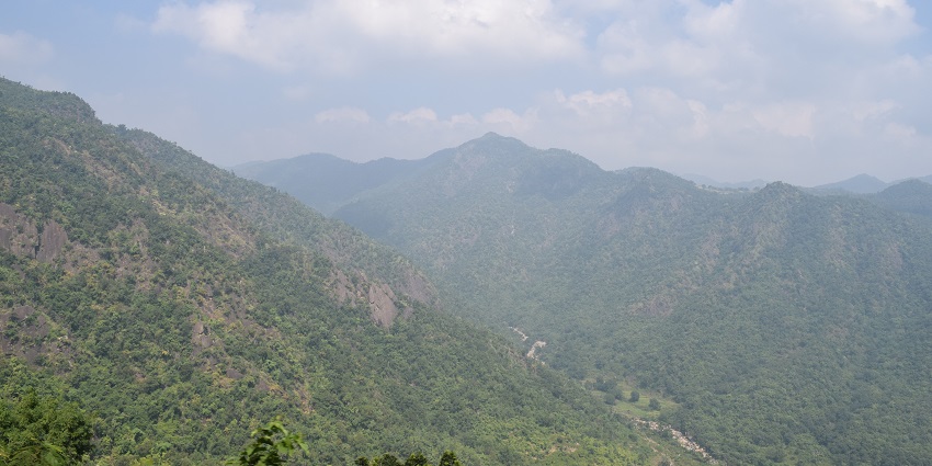 Image of picturesque Araku valley surrounded by lush greenery under the clear blue sky.