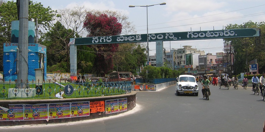 Signboard of Guntur Municipal Corporation displaying the city's name and logo.
