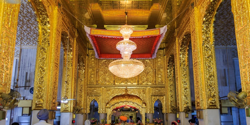 A picture of the inner prayer sanctum of a gurudwara, decorated with gold plating