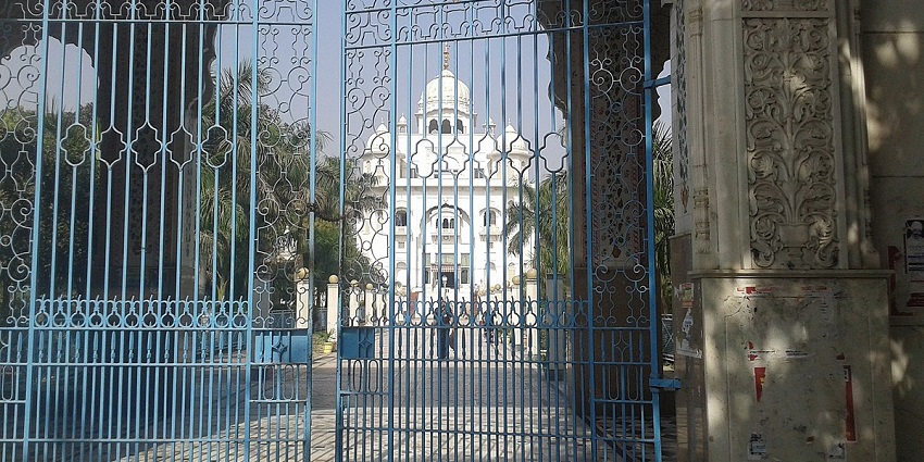 The entry gate of Gurudwara Rakab Ganj with the main temple visible in the background