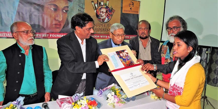 A picture of an award ceremony happening at an art gallery in Guwahati with people distributing certificates