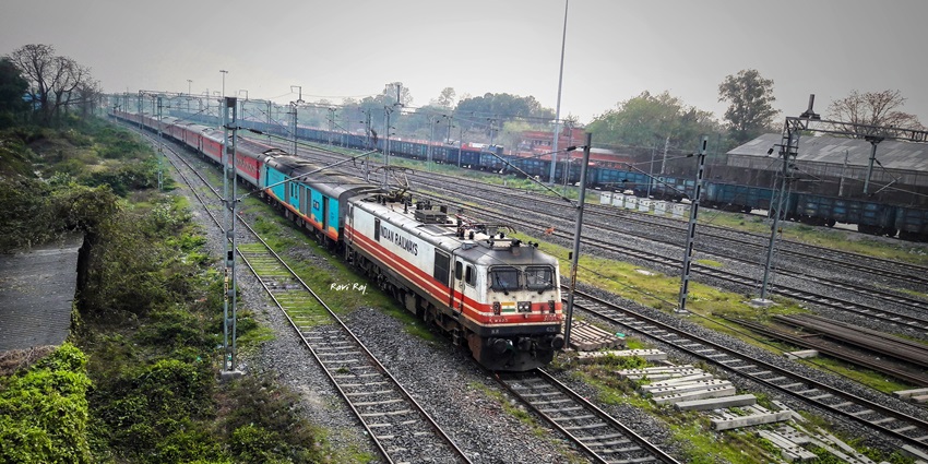 A busy railway yard in Katihar, showcasing trains and tracks under a clear sky.