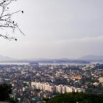 A breathtaking aerial view of Guwahati with a lot of houses and trees during the daytime.