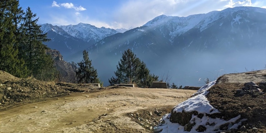 A picture of a picturesque mountain with rugged trails and a cover of trees all around