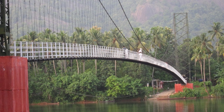A view of the iconic Hanging Bridge over shimmering waters and surrounded by greenery.