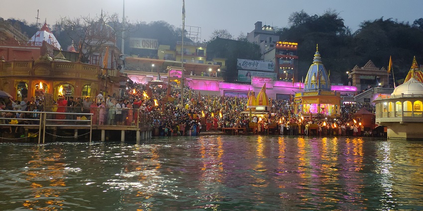 A picture of a ghat at the Ganga River with thousands of devotees praying in the evening