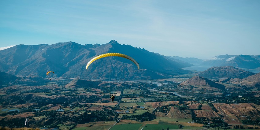 A picturesque view of a person gliding high up in the air in the scenic Hee Bermiok.