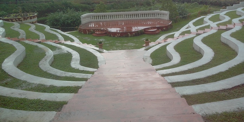 Terraced curves around an open-air stage nestled within lush greenery at Heritage Park