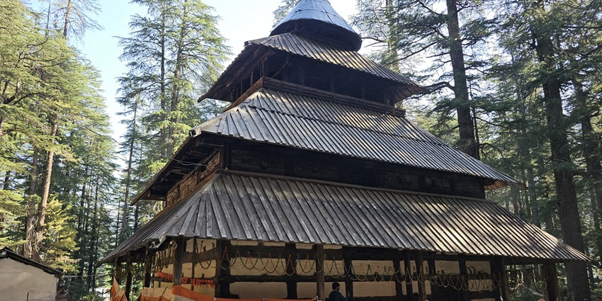 Hidimba Devi Temple in Manali, featuring unique wooden architecture surrounded by dense cedar forests.
