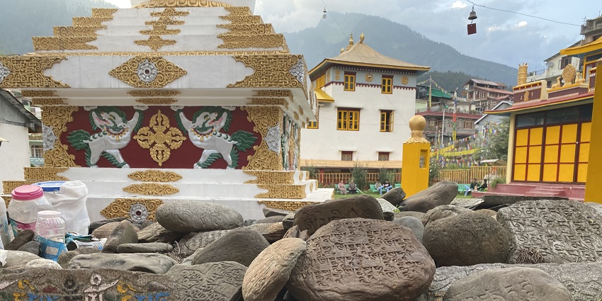 A frontal view of a temple in Manali with Tibetan texts written on rocks near the Tibetan Monastery