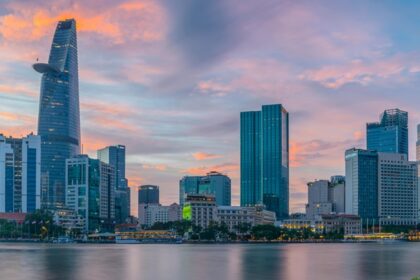 A scenic view of towering buildings surrounded by glistening waters of the region.