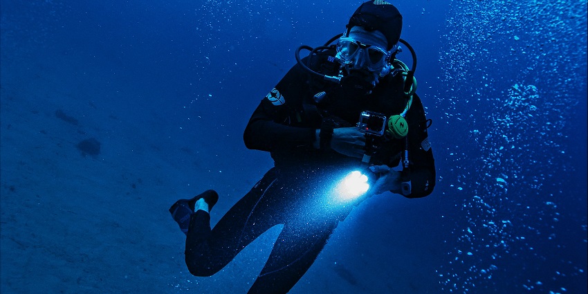 Man underwater in the ocean, swimming and exploring the aquatic environment.