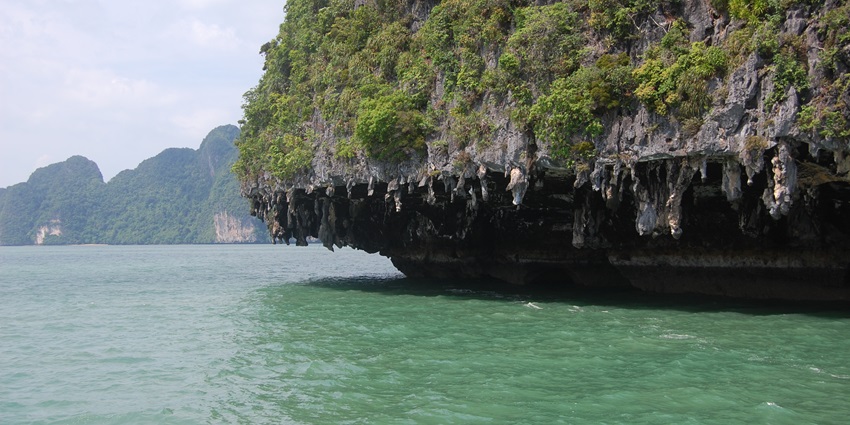 Beautiful snapshot of the Hong Island hill hanging over the green ocean water in Thailand
