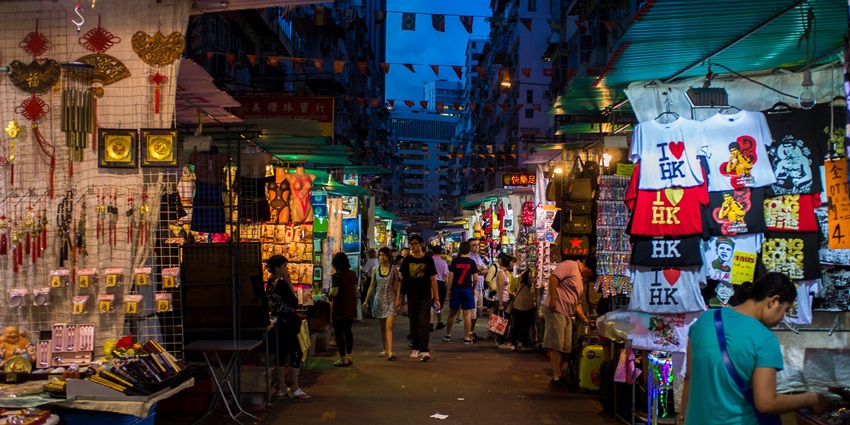 Vibrant Hong Kong street market bustling with vendors, colorful stalls, and shoppers.