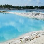 A breathtaking view of a hot spring with azure waters under a cloudy sky during the day.