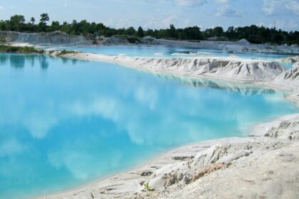 A breathtaking view of a hot spring with azure waters under a cloudy sky during the day.