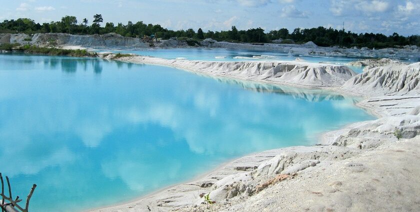 A breathtaking view of a hot spring with azure waters under a cloudy sky during the day.