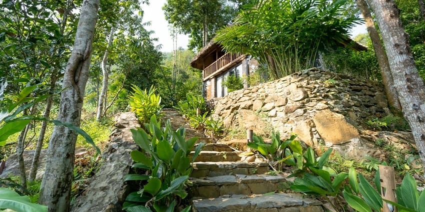 Beautiful image of a small cottage amidst the hills and lush green desne trees